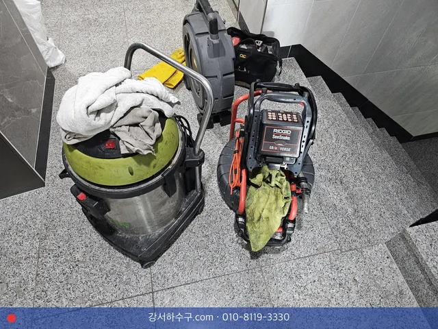 계단참에 내려 둔 습식 청소기와 내시경 릴, 작업용 걸레