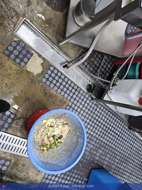 주방 바닥 배수로 옆 소쿠리에 건져 둔 음식 찌꺼기